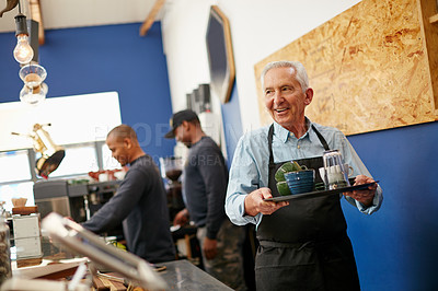 Buy stock photo Shot of a senior man working in a coffee shop