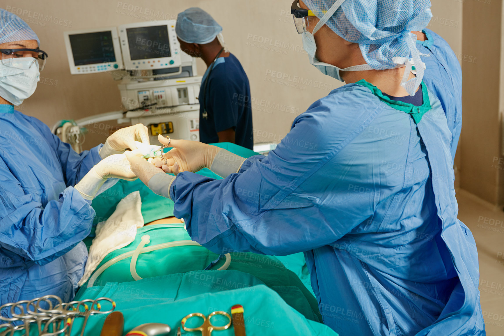 Buy stock photo Shot of a team of surgeons preparing for a surgical procedure