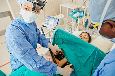 Buy stock photo Shot of a surgeon using a defibrillator on a patient during surgery