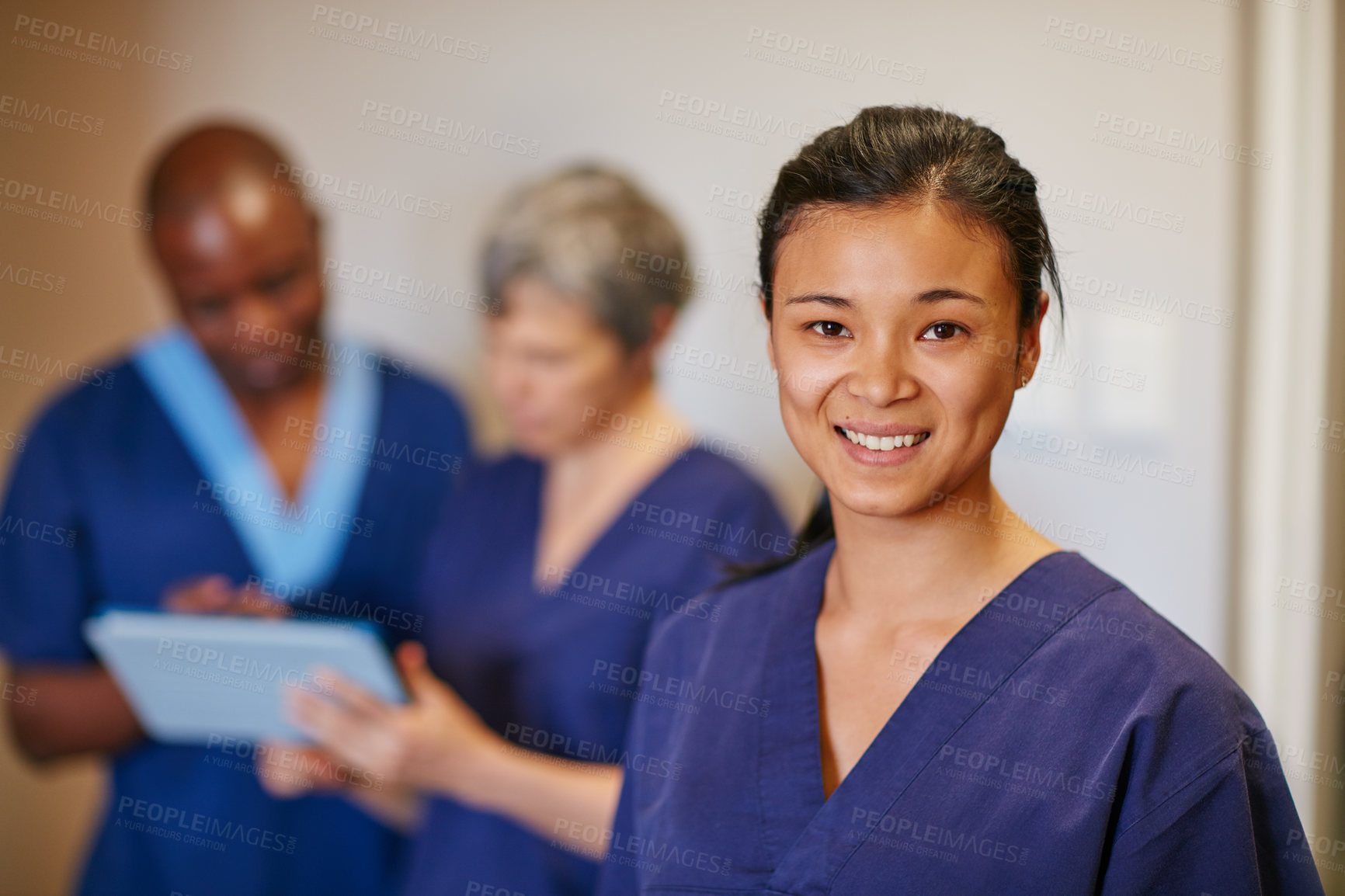 Buy stock photo Cropped portrait of a female nurse standing in a hospital with her colleagues in the background