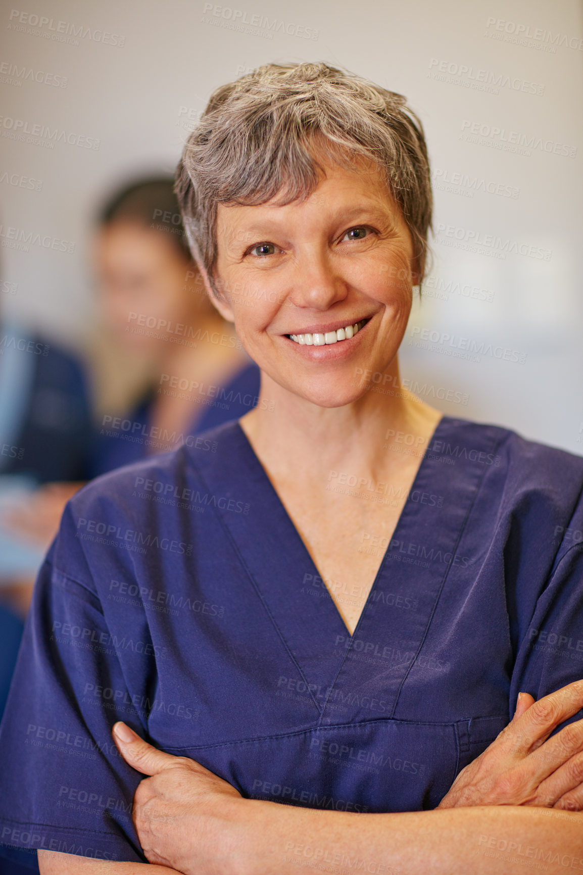 Buy stock photo Cropped portrait of a female doctor standing in a hospital with her colleagues in the background