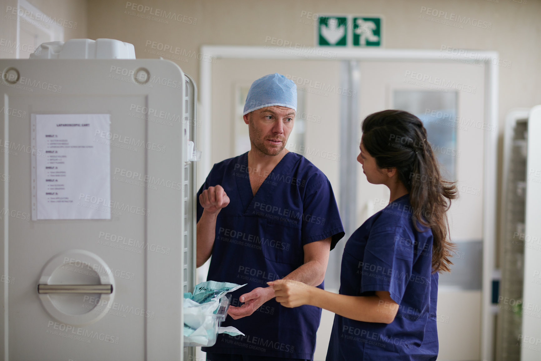 Buy stock photo Shot of two medical practitioners having a chat in a hospital