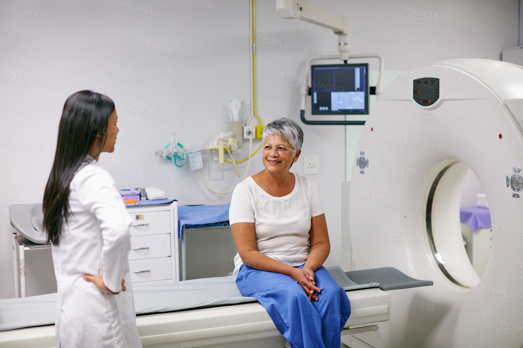 Buy stock photo Shot of a senior woman talking with a doctor before and MRI scan