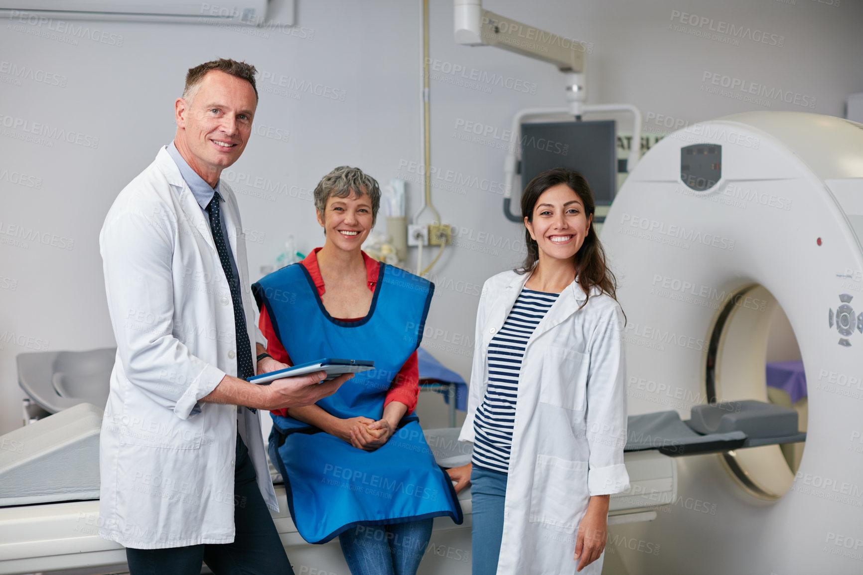 Buy stock photo Portrait of a mature woman and two doctors sitting by an MRI scanner