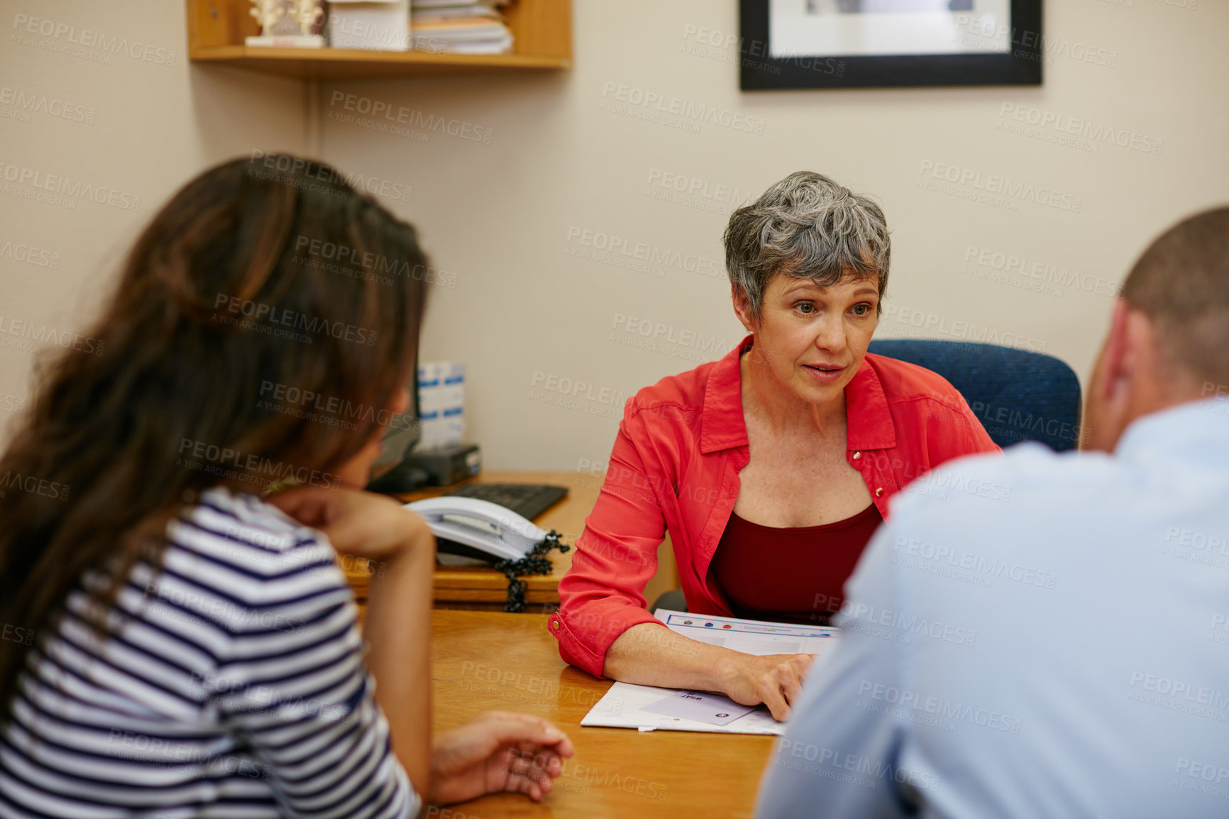 Buy stock photo Rearview shot of a couple sitting in a meeting with their financial advisor