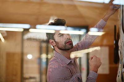 Buy stock photo Shot of a young businessman working on a project
