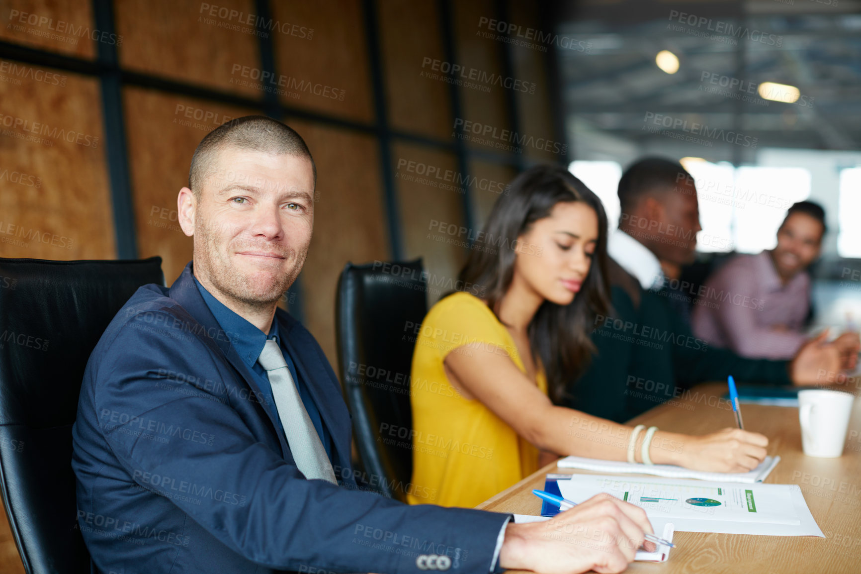 Buy stock photo Portrait of an office worker in a meeting with colleagues in the background