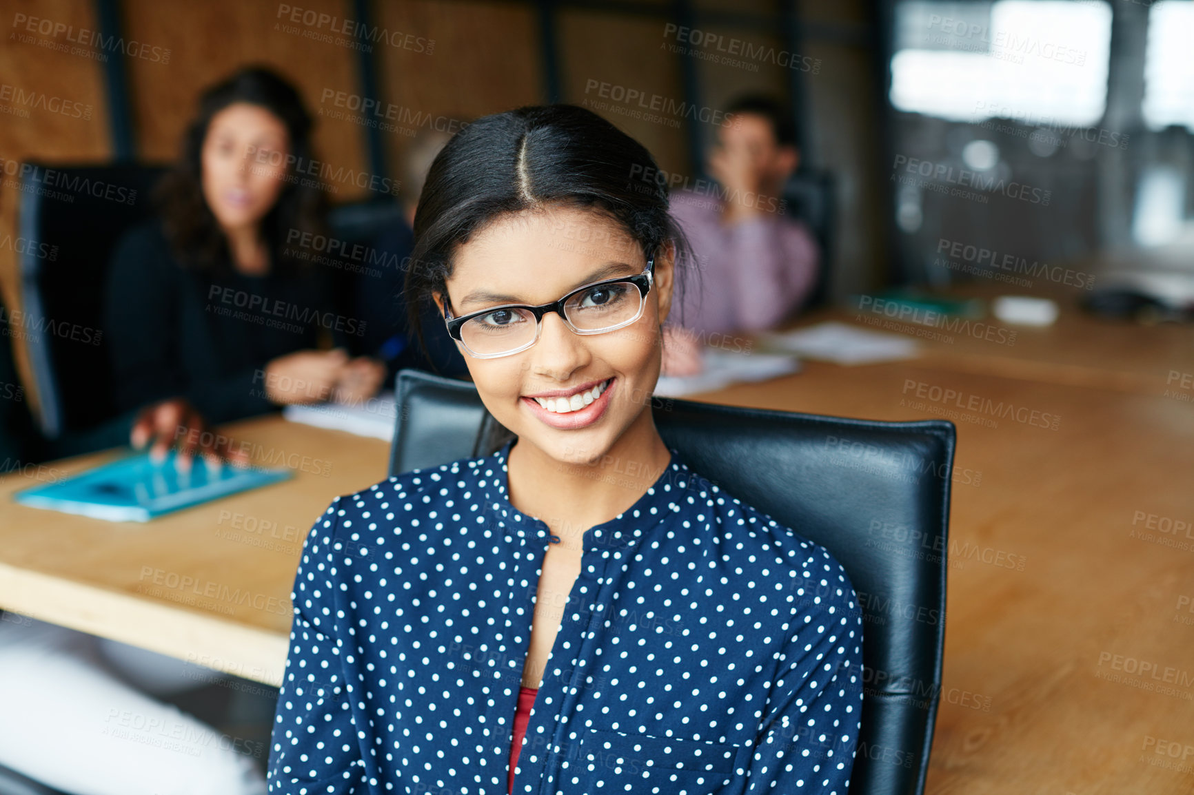 Buy stock photo Portrait of an office worker in a meeting with colleagues in the background