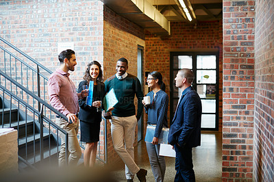 Buy stock photo Shot of a group of businesspeople having a discussion in the hallway