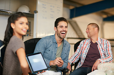 Buy stock photo Shot of team of colleagues having an informal meeting with a digital tablet