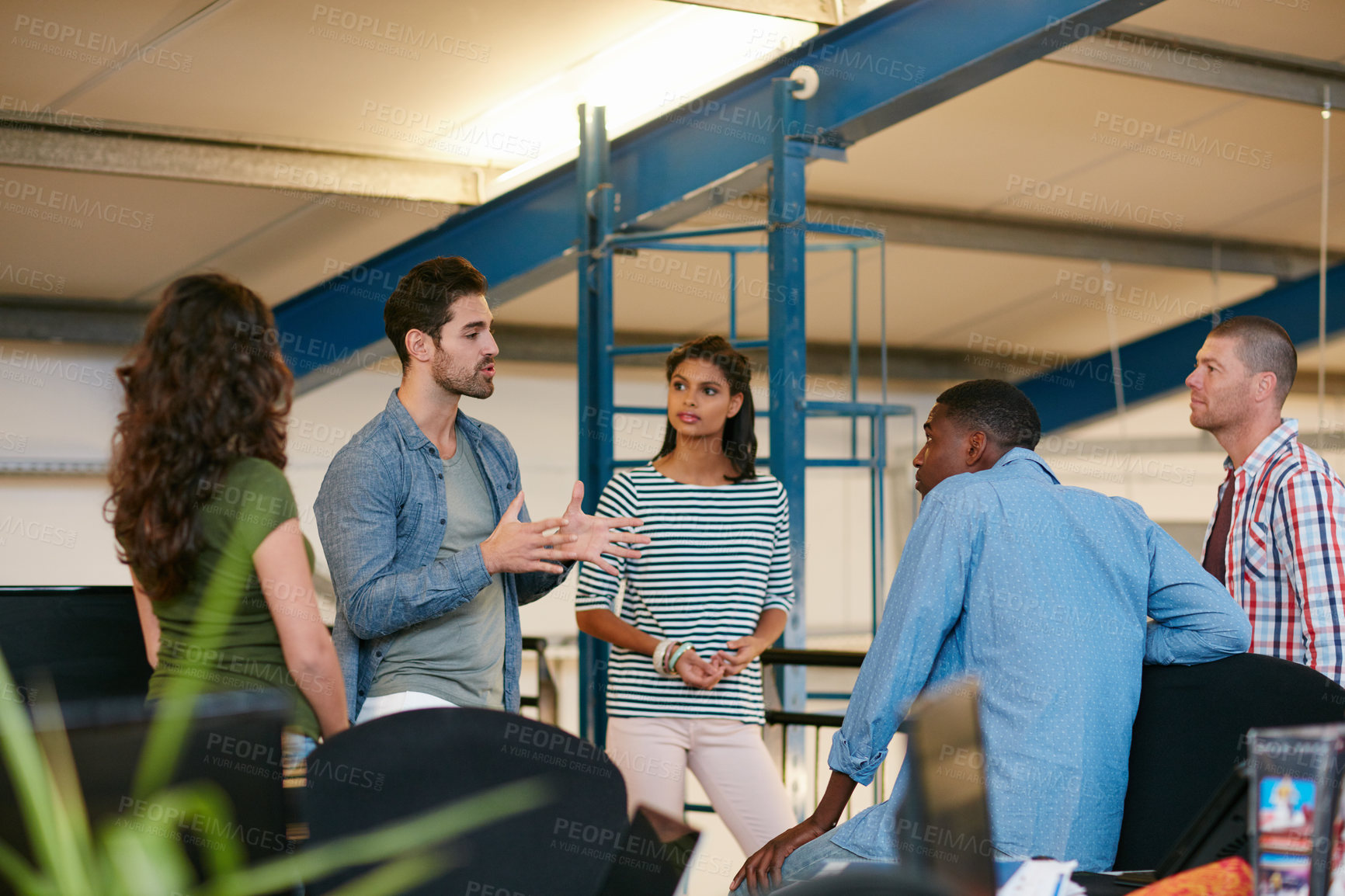 Buy stock photo Shot of a team of colleagues having an informal meeting in a modern office