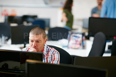 Buy stock photo Shot of a man using a computer in a modern office