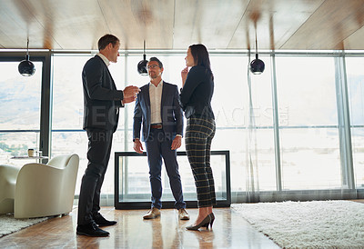 Buy stock photo Shot of three businesspeople talking in a corporate office