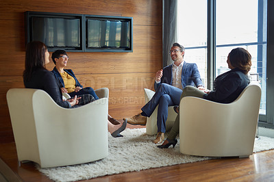 Buy stock photo Shot of four businesspeople talking in a corporate office