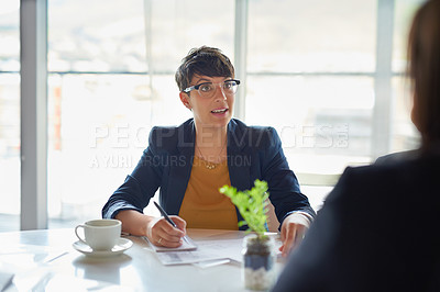 Buy stock photo Shot of two corporate businesspeople sitting in the boardroom