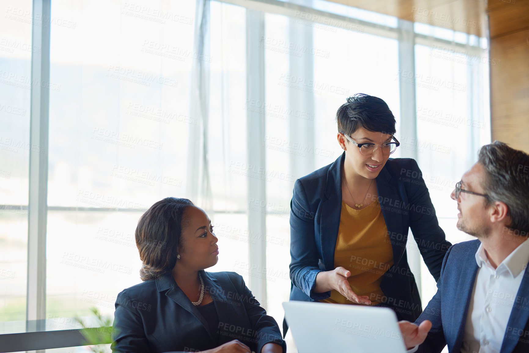 Buy stock photo Shot of three corporate businesspeople working in the boardroom