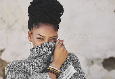 Buy stock photo Cropped portrait of an attractive young woman covering her mouth with her poncho