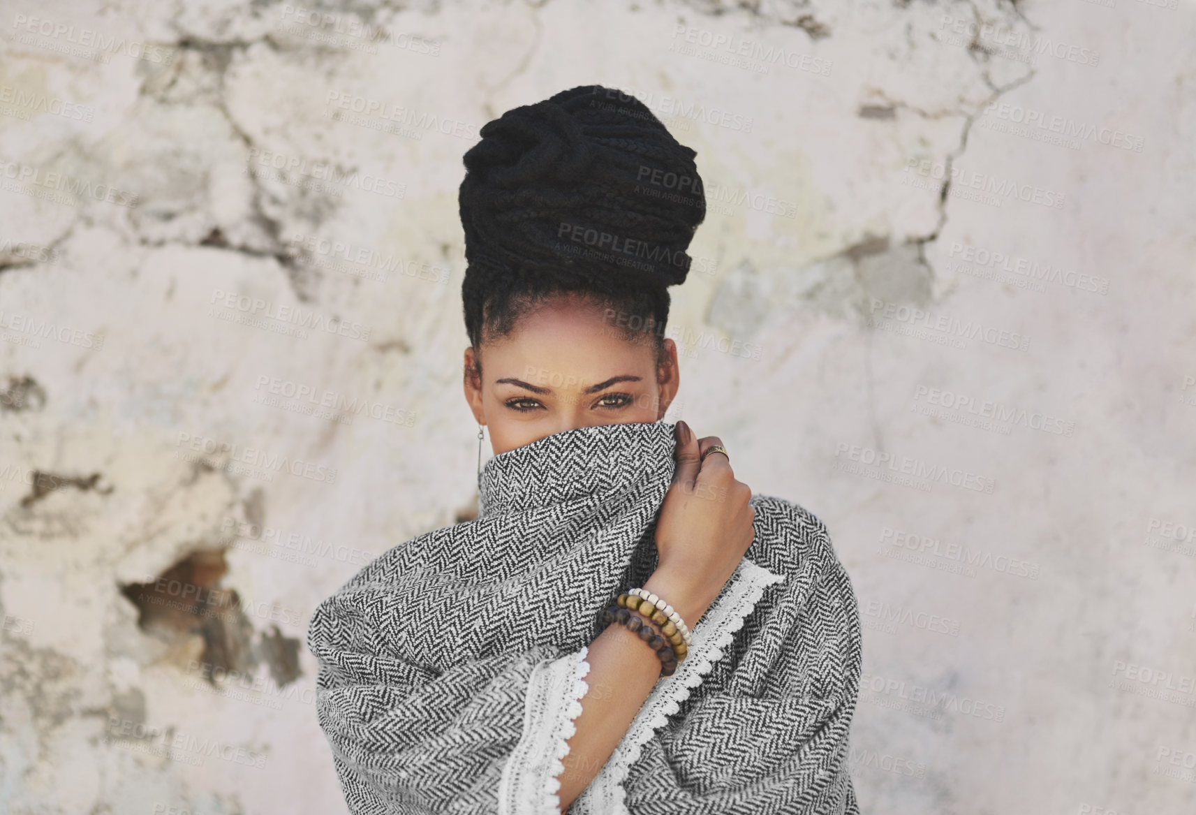 Buy stock photo Cropped portrait of an attractive young woman covering her mouth with her poncho