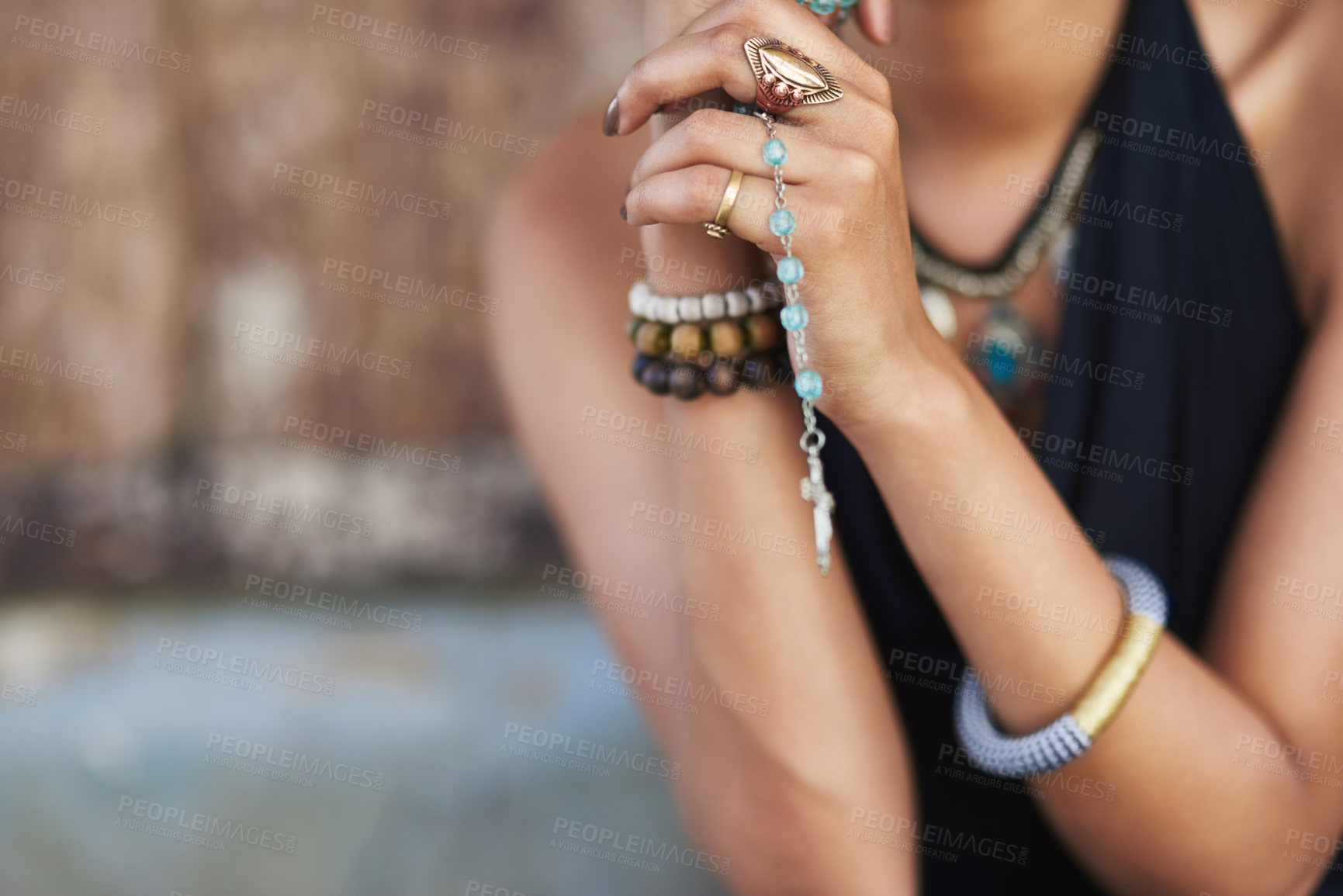 Buy stock photo Shot of a young woman praying with her rosary outdoors