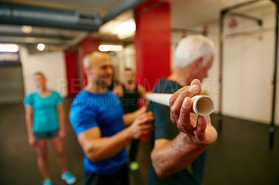 Buy stock photo Shot of a senior man doing pvc pipe exercises with the assistance of his trainer