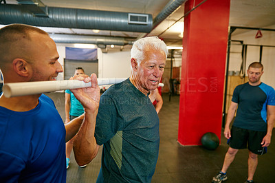 Buy stock photo Shot of a senior man doing pvc pipe exercises with the assistance of his trainer