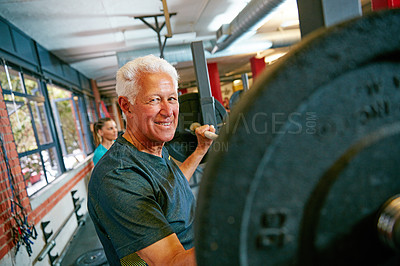 Buy stock photo shot of a senior man lifting weights at the gym