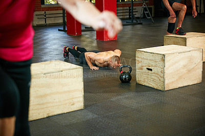 Buy stock photo Shot of a shirtless man doing push ups during his workout at the gym