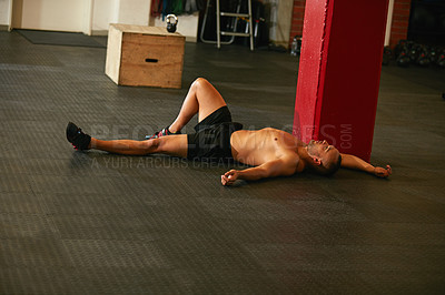 Buy stock photo Shot of a young man taking a break from an exhausting workout