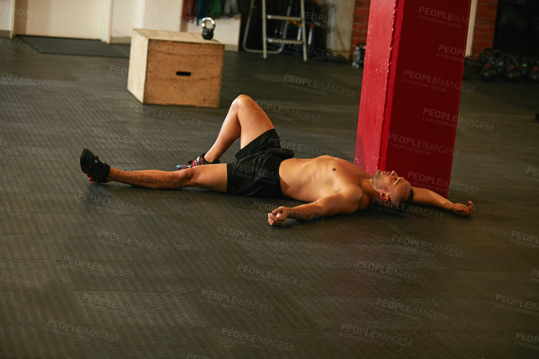 Buy stock photo Shot of a young man taking a break from an exhausting workout