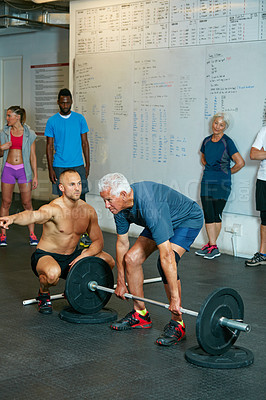 Buy stock photo Shot of a senior man working out with his fitness coach