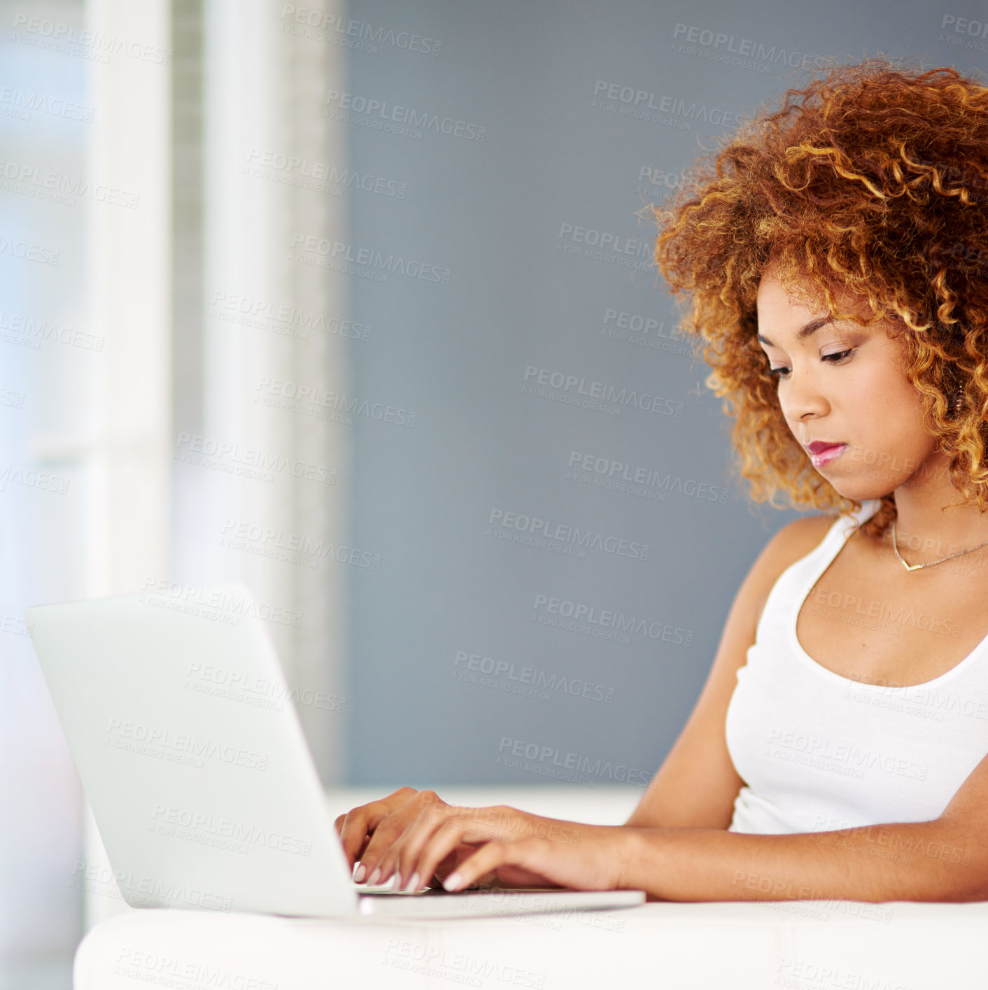 Buy stock photo Shot of a young woman using a laptop on the sofa at home