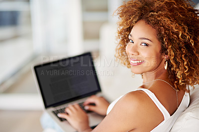 Buy stock photo Portrait of a young woman using a laptop on the sofa at home