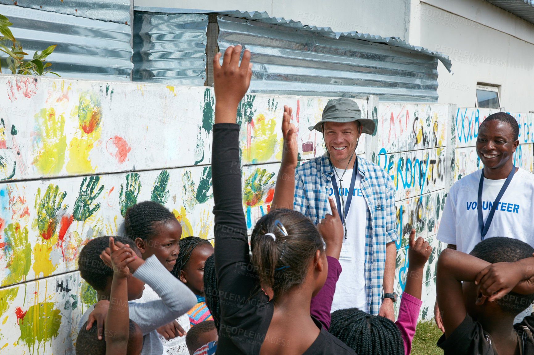 Buy stock photo Happy people, volunteer and community with hands raised for question or charity service in poverty. Group, NGO or outreach with smile or kids for global change, society aid or welfare in rural area