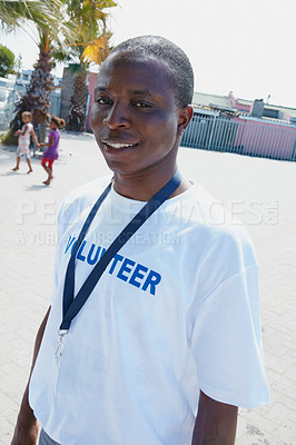 Buy stock photo Cropped portrait of a volunteer worker with two young children in the background at a community outreach event