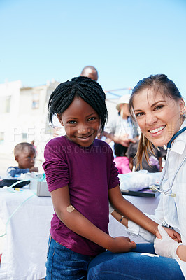 Buy stock photo Portrait of a volunteer doctor giving checkups to underprivileged kids