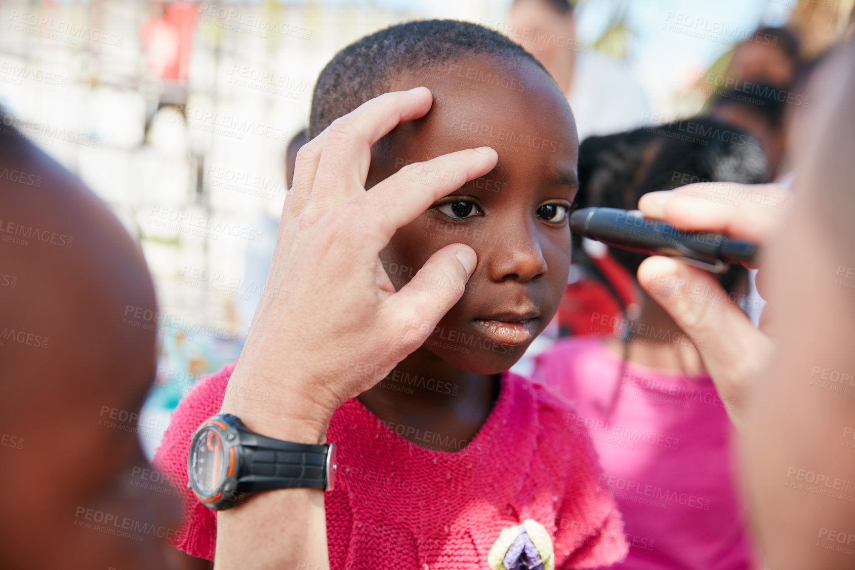 Buy stock photo Shot of a volunteer doctor giving checkups to underprivileged kids