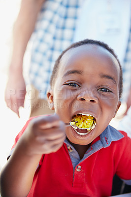 Buy stock photo Cropped portrait of a young boy getting fed at a food outreach
