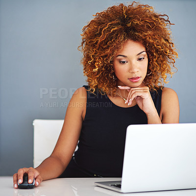 Buy stock photo Shot of a young businesswoman working on a laptop at her desk