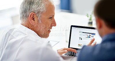 Buy stock photo Rearview shot of two men working in the office