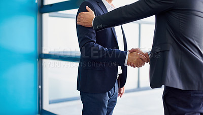 Buy stock photo Cropped shot of two businessmen shaking hands in the lobby