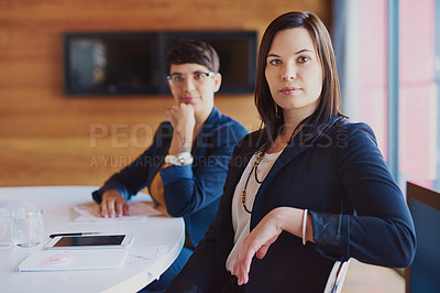 Buy stock photo Cropped portrait of a businesswoman sitting in the boardroom with a colleague in the background