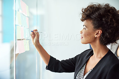 Buy stock photo Shot of a businesswoman making notes on a glass board