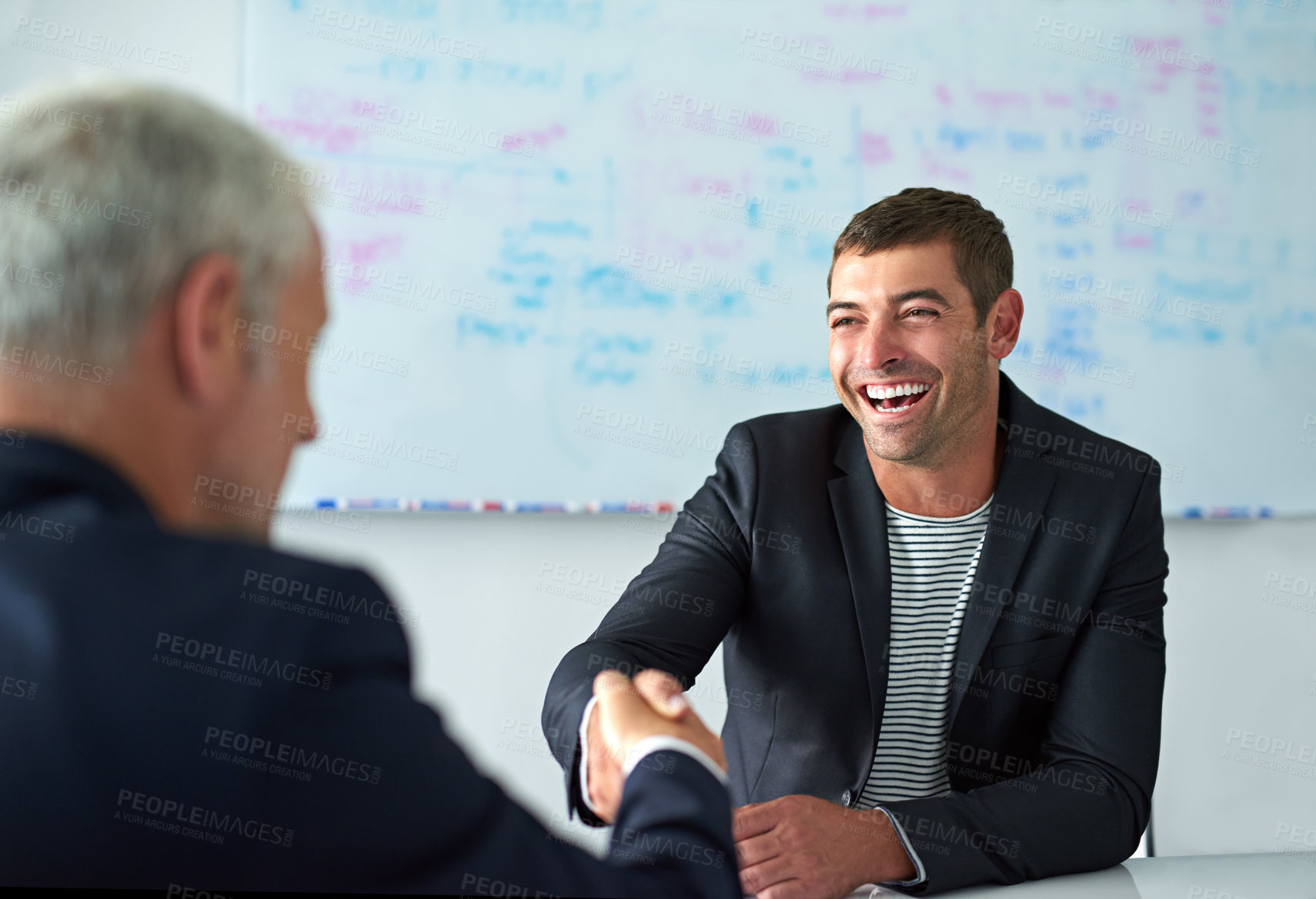 Buy stock photo Shot of a businessman shaking hands with a colleague in a meeting