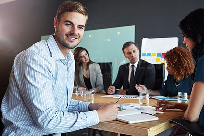 Buy stock photo Portrait of a businessman in a meeting with his colleagues in the background