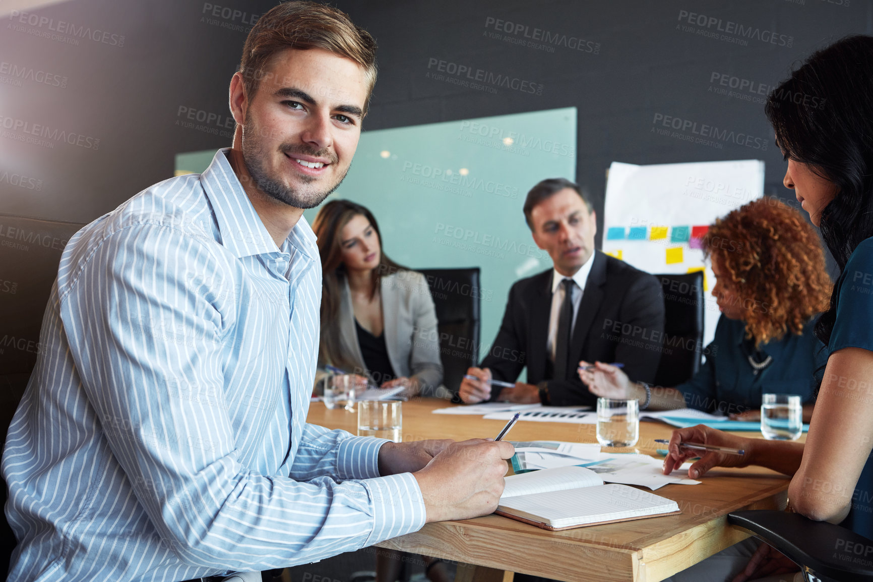 Buy stock photo Portrait of a businessman in a meeting with his colleagues in the background