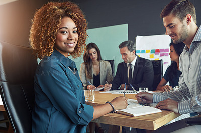 Buy stock photo Portrait of a businesswoman sitting in a meeting with her colleagues blurred in the background