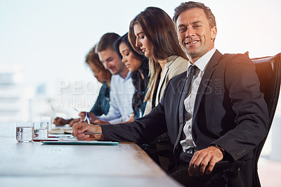Buy stock photo Portrait of a businessman in a meeting with his colleagues in the background