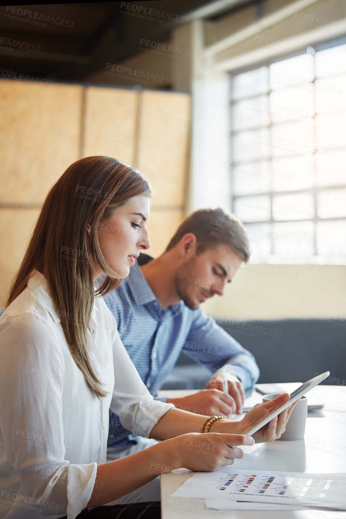 Buy stock photo Cropped shot of two businesspeople working in the office