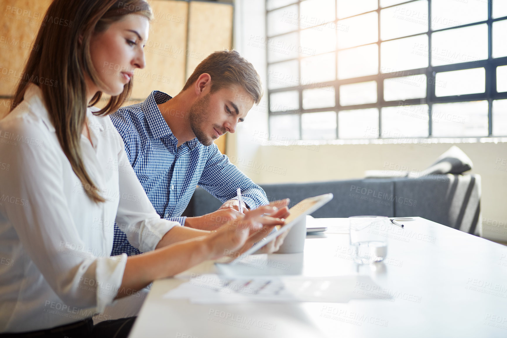 Buy stock photo Cropped shot of two businesspeople working in the office