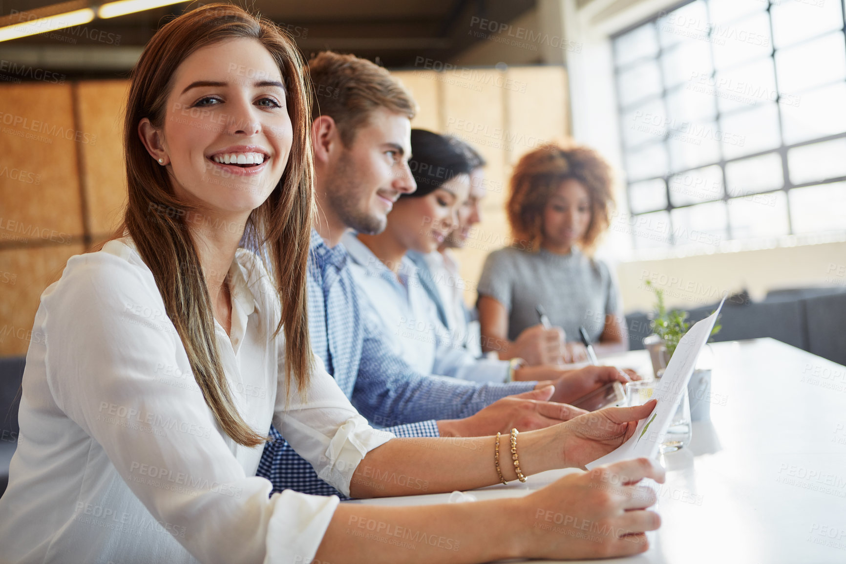 Buy stock photo Cropped portrait of a young businesswoman working in the office with her colleagues